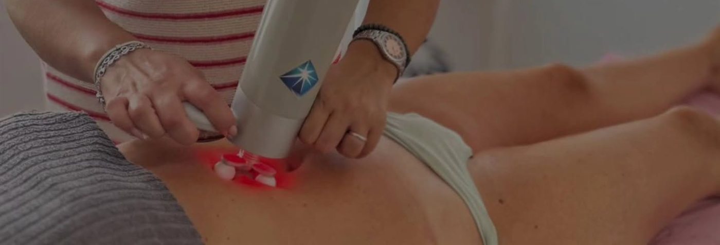 Tamara aplicando el cabezal del Bellaction, con su luz roja, sobre el abdomen de una clienta.